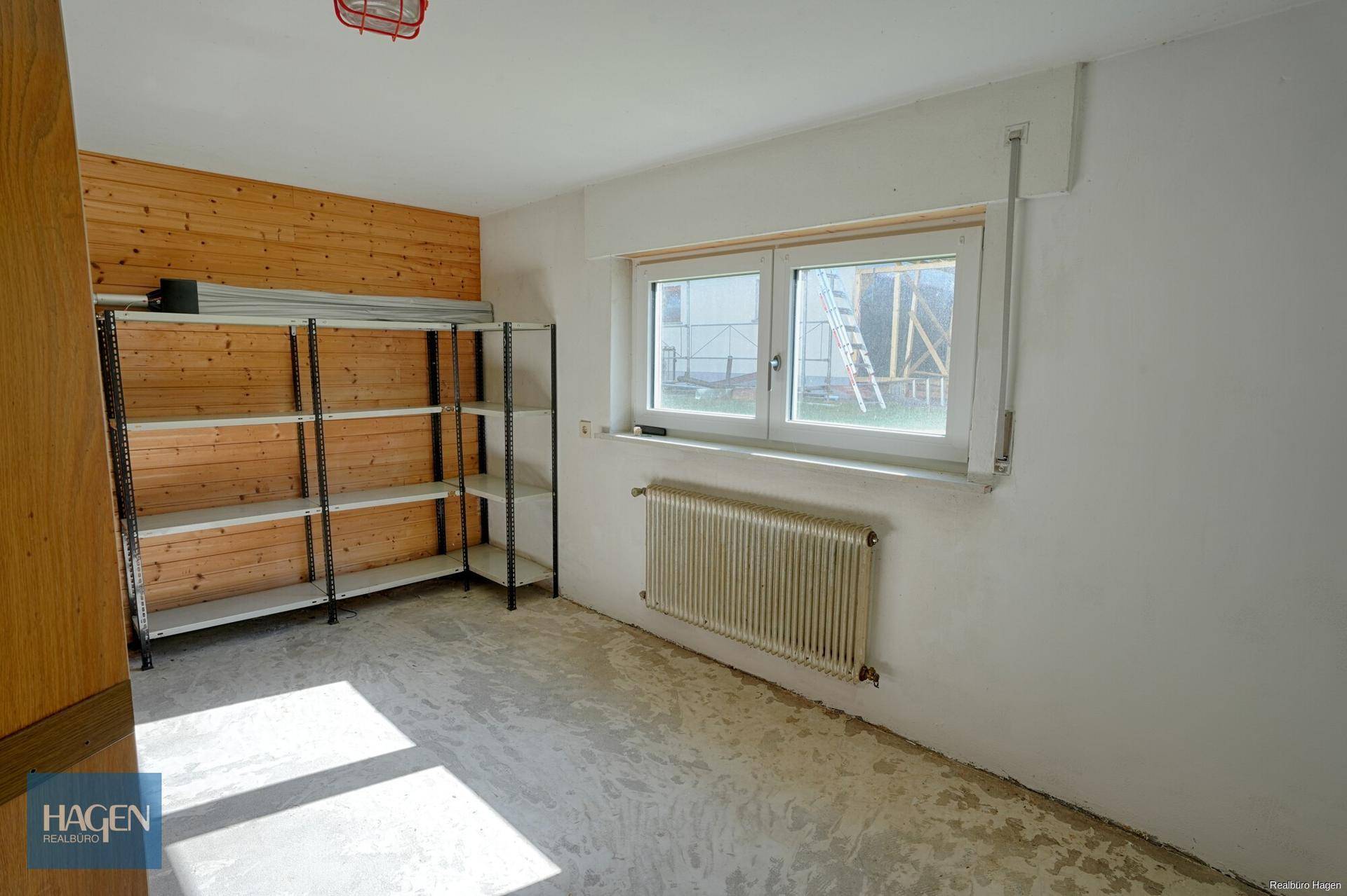 Abstellraum mit Holzverkleidung, Regalen und Fenster, ideal für Lagerung.
