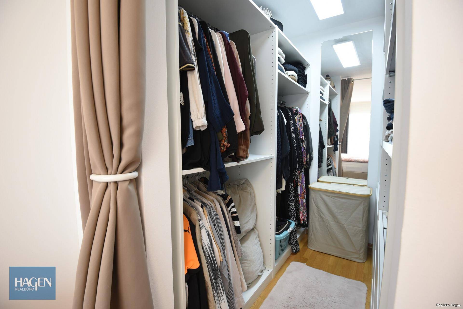 Begehbarer Kleiderschrank mit Regalen und viel Stauraum für Kleidung.