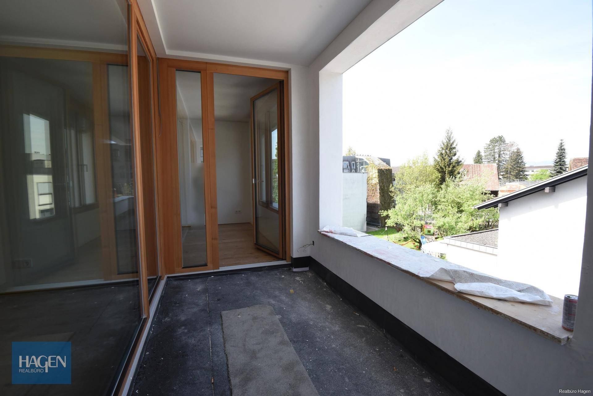 Geräumiger Balkon mit Blick ins Grüne und auf die umliegenden Gebäude.