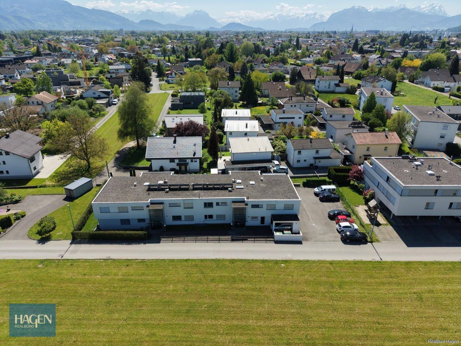 Luftaufnahme der Wohnanlage in einer Siedlung mit Bergblick im Hintergrund.