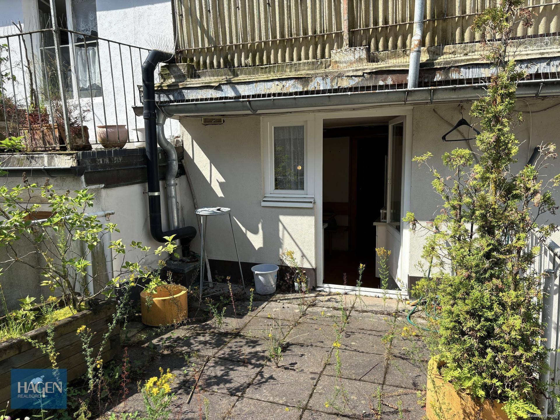 Kleiner Terrassenbereich mit Pflanzen und Zugang zu einem Innenraum.