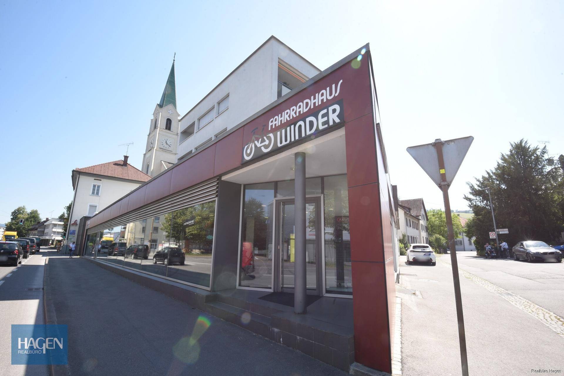 Eingangsbereich des Fahrradgeschäfts mit großen Schaufenstern und moderner Fassadengestaltung.
