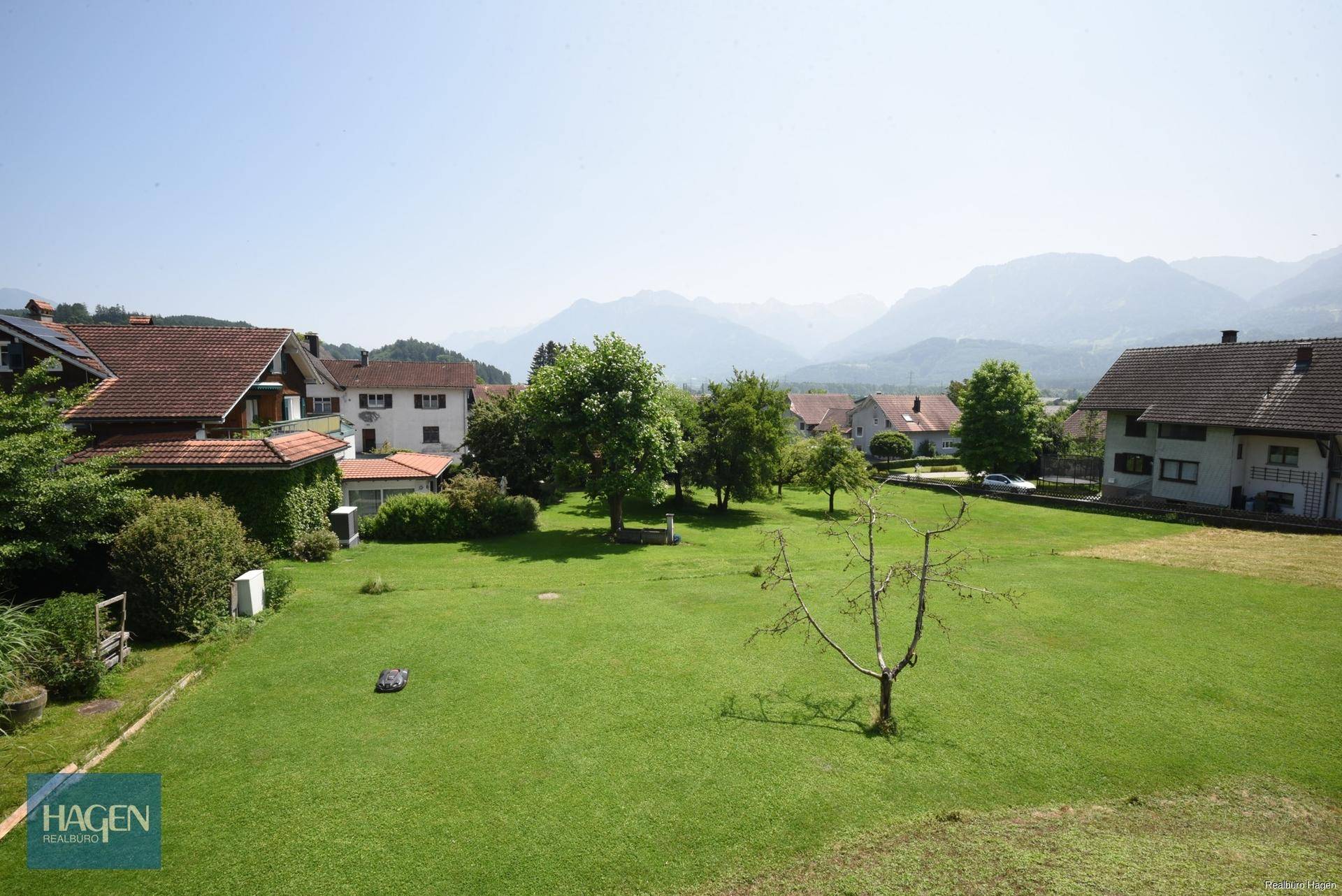 Panoramablick auf die umliegende Landschaft mit Häusern und Bergen.