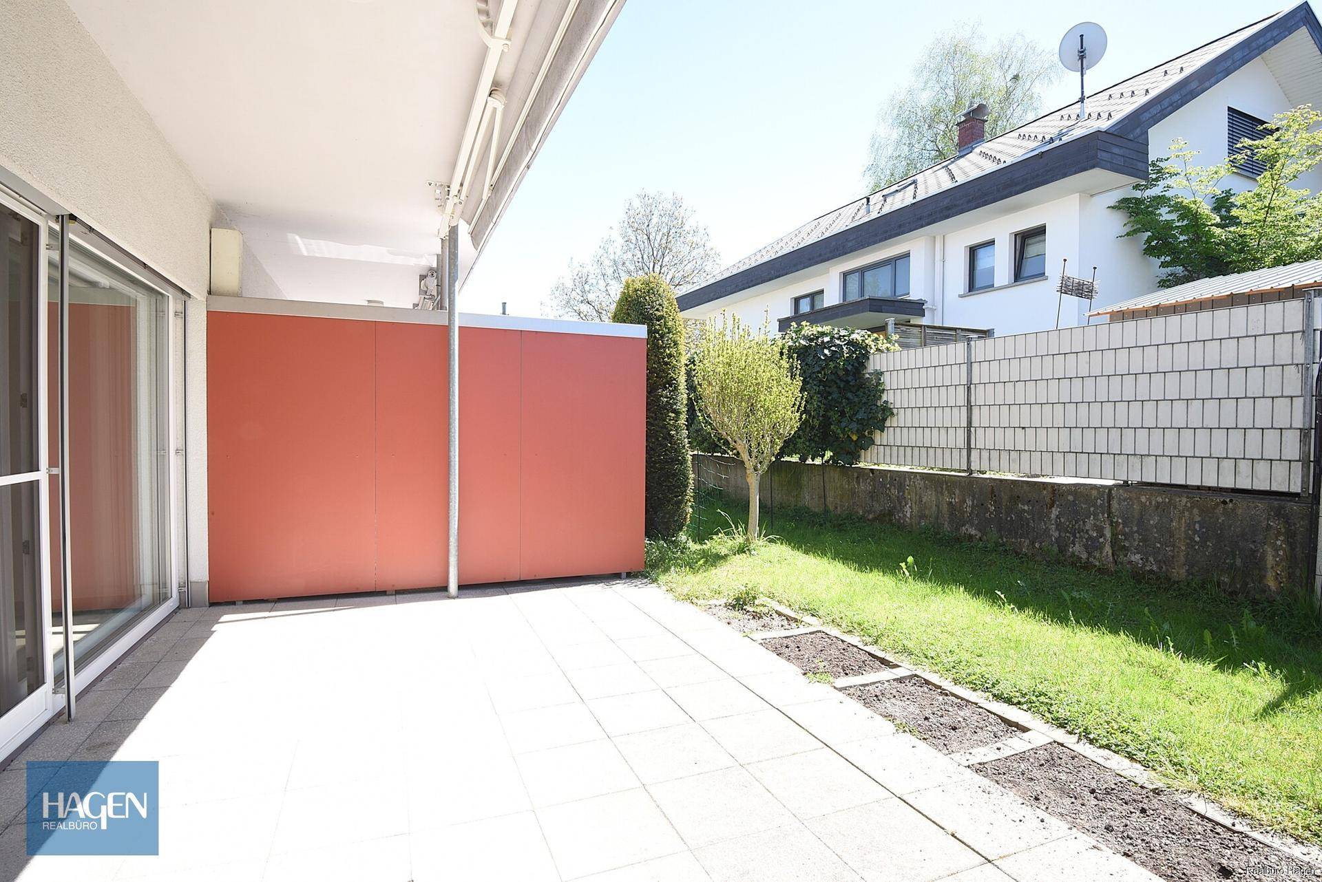 Weitläufige Terrasse mit Fliesen und Blick auf die umliegenden Häuser und Grünflächen.