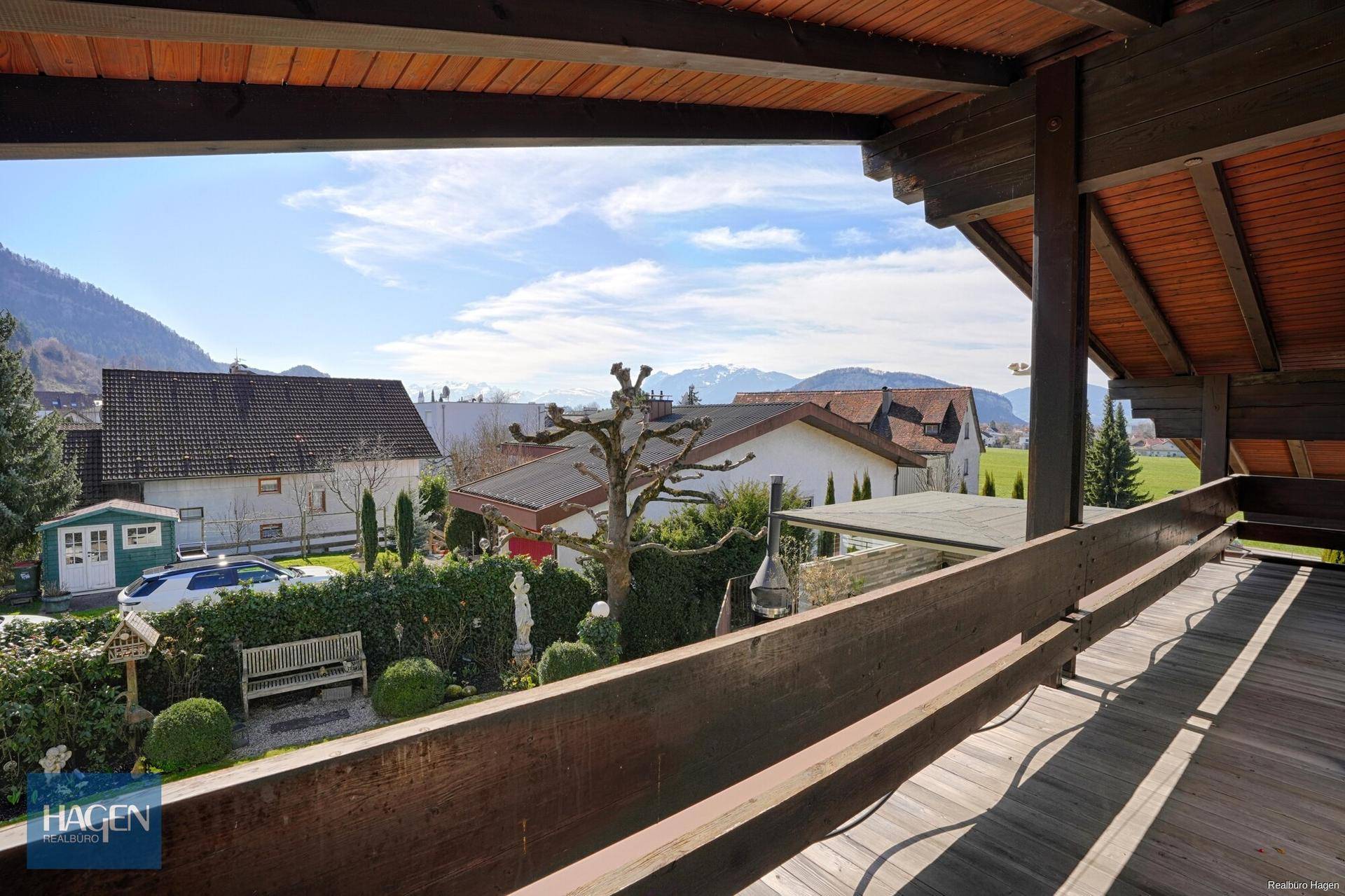 Weitläufiger Balkon mit Holzboden und Panoramablick auf die umliegende Landschaft und Berge.