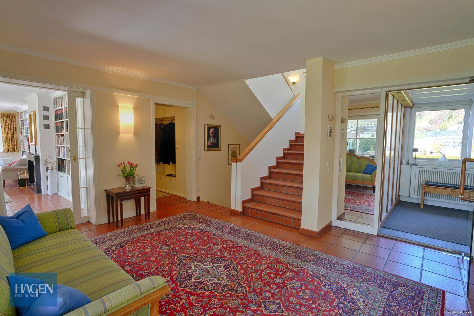 Geräumiger Flur mit Terrakottafliesen, Treppe und Zugang zu den verschiedenen Wohnbereichen.