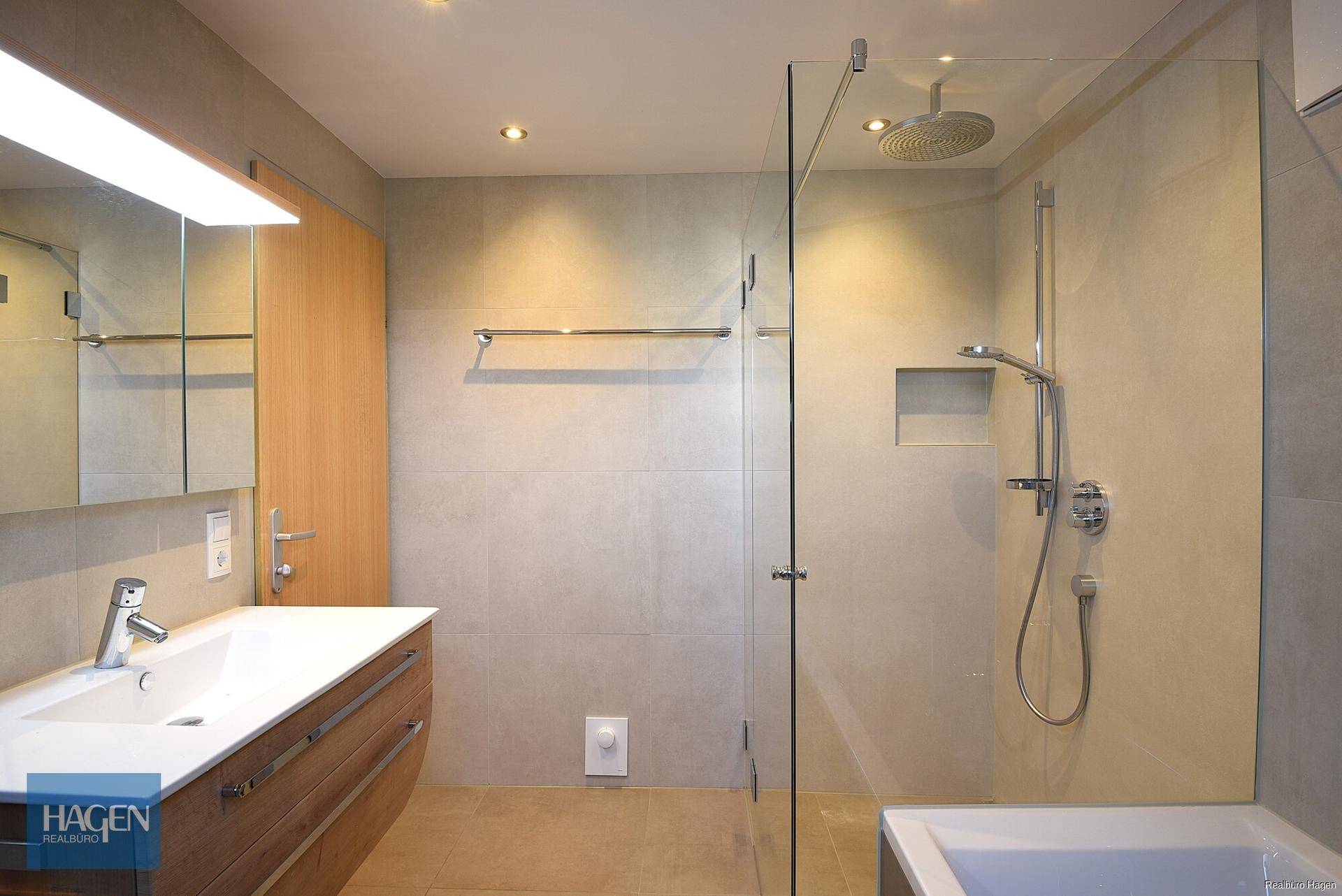 Modernes Badezimmer mit begehbarer Dusche, Regendusche und eleganten Fliesen.