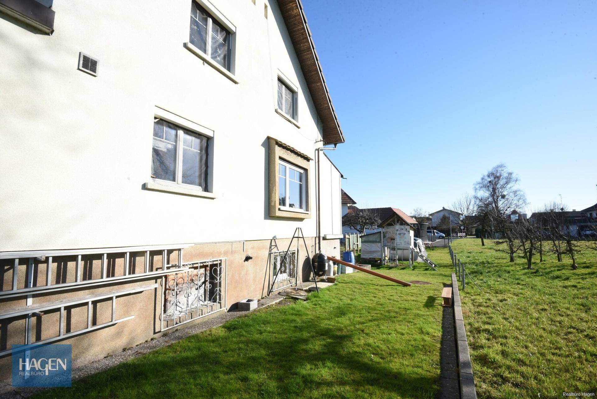 Seitenansicht des Hauses mit Rasenfläche und Blick in den Garten.