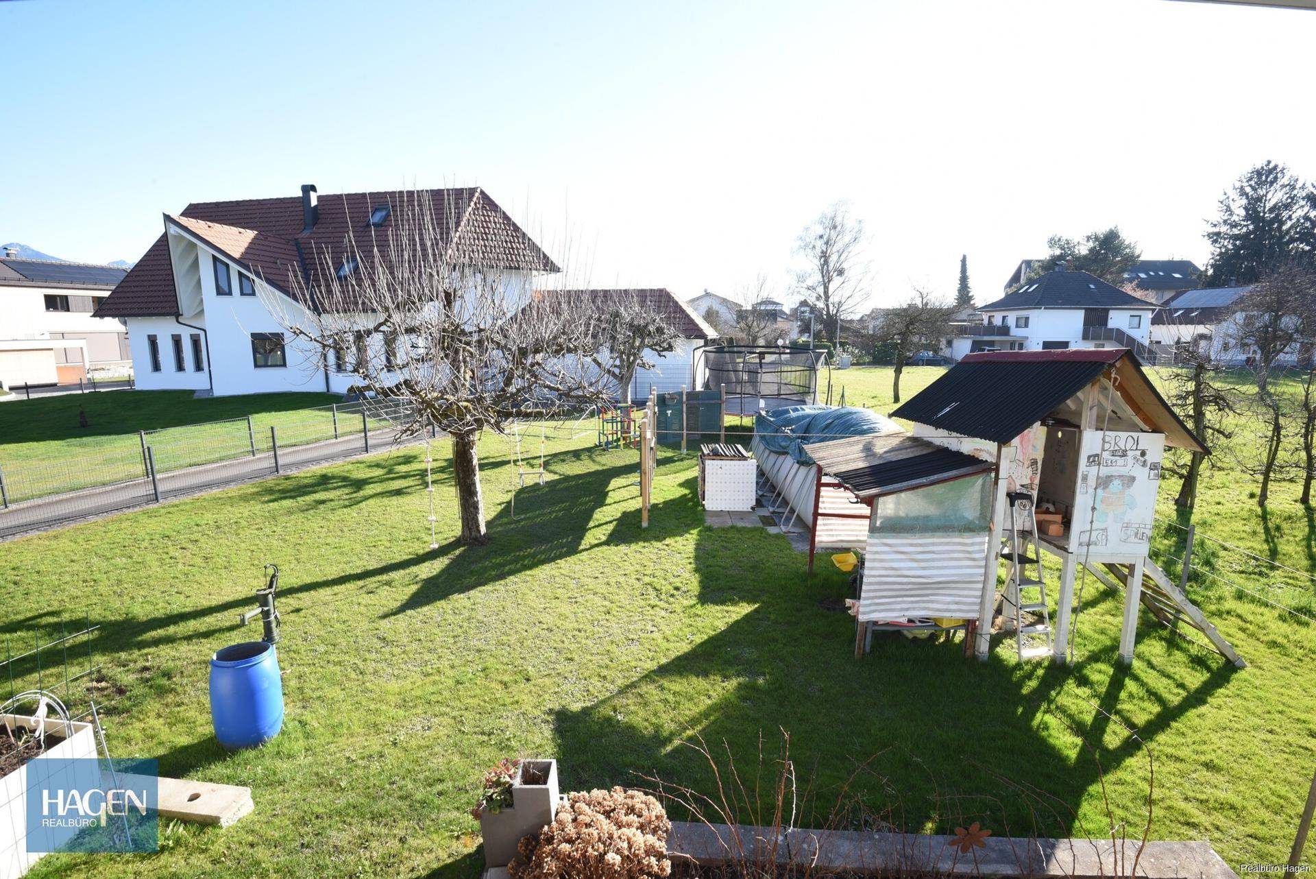 Großer Garten mit Rasenfläche, Spielhaus und Blick auf die Umgebung.