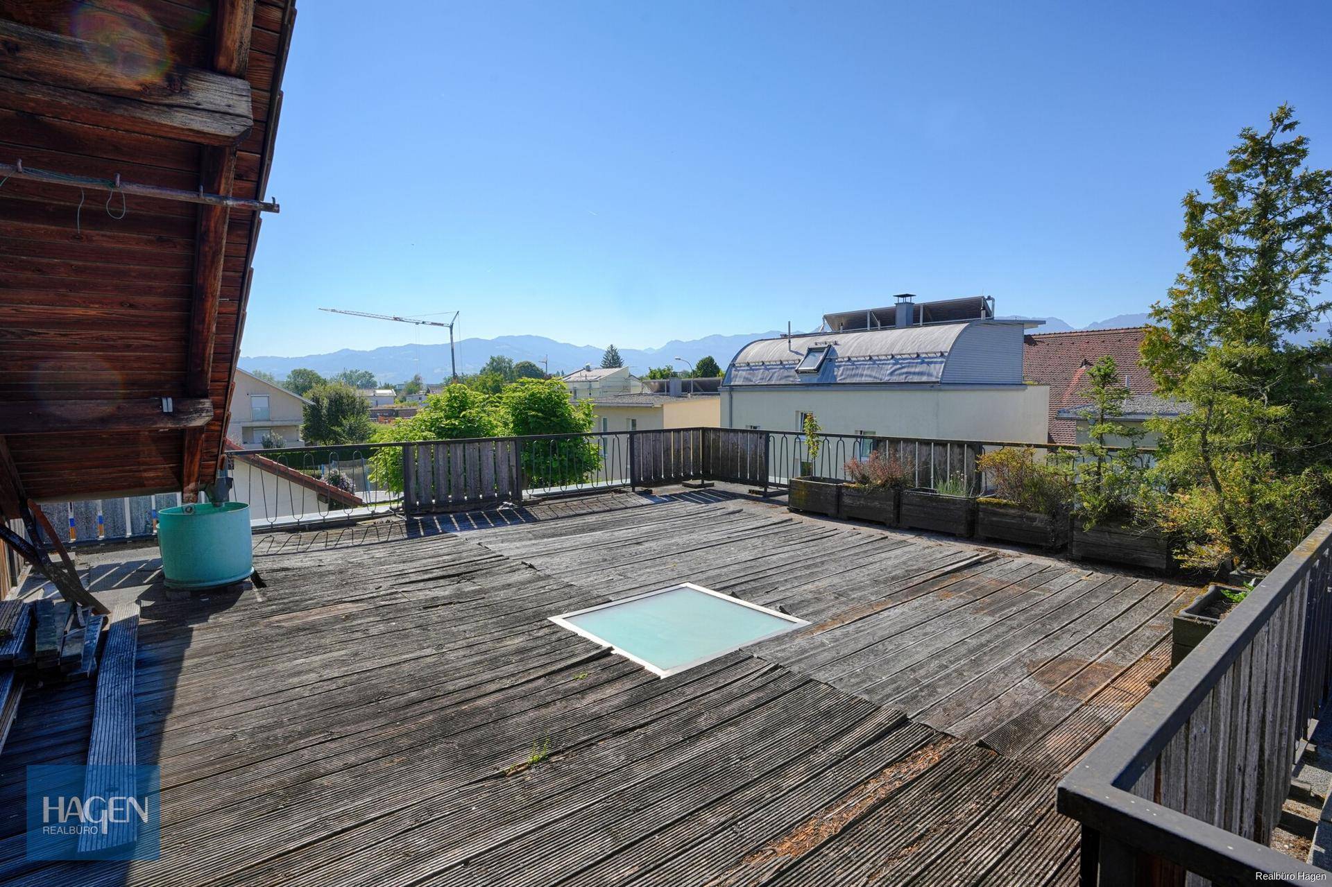 Große Dachterrasse mit Holzboden und weitem Blick auf die Berge.
