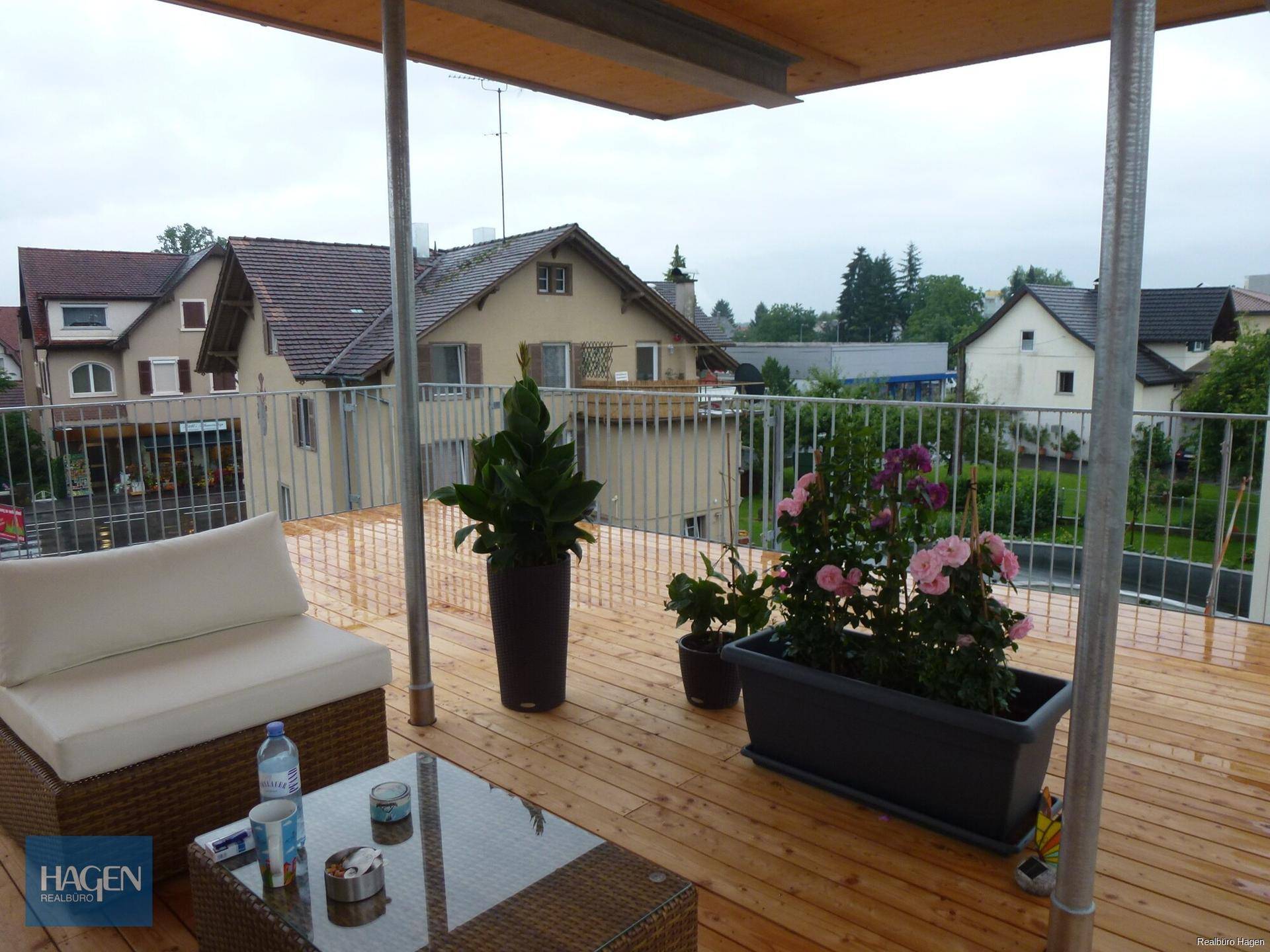 Gemütliche Terrasse mit Sitzgelegenheiten und Pflanzen, ideal zum Entspannen im Freien.