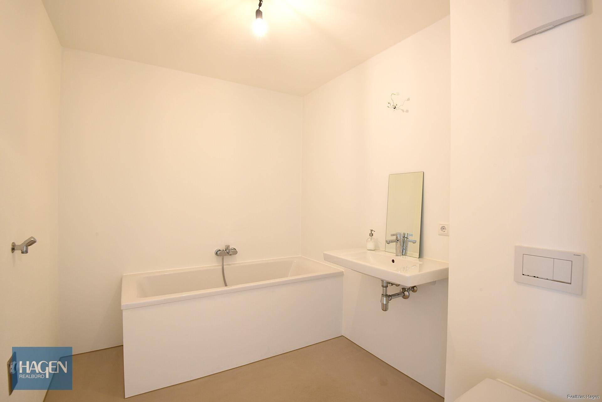 Modernes Badezimmer mit Badewanne, Waschbecken und wandhängendem WC in hellen Farbtönen.
