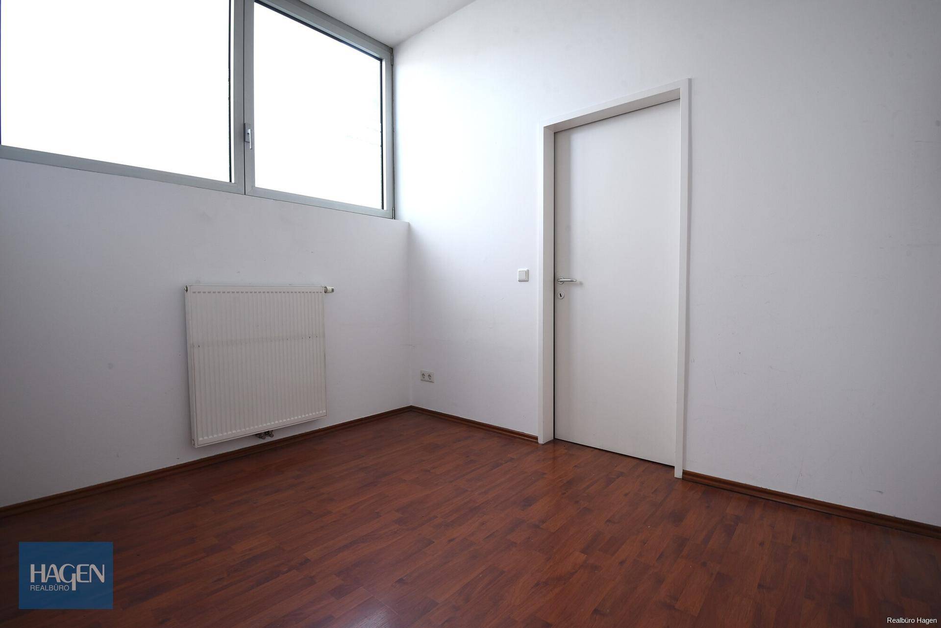 Kleiner, heller Raum mit Fenster und Heizkörper, ideal als Büro oder Lagerbereich nutzbar.
