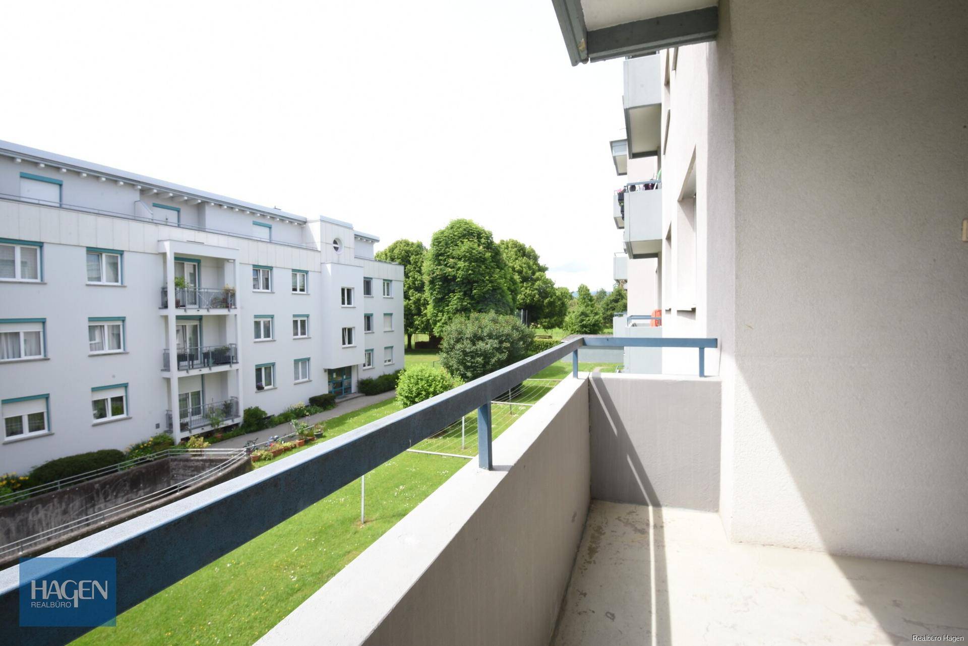 Geräumiger Balkon mit Blick auf die Wohnanlage und grüne Flächen, bietet viel Platz.