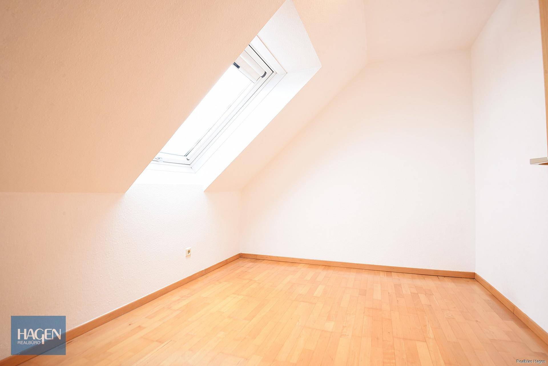 Heller Dachbodenraum mit Dachschräge und großem Dachfenster für viel Tageslicht.