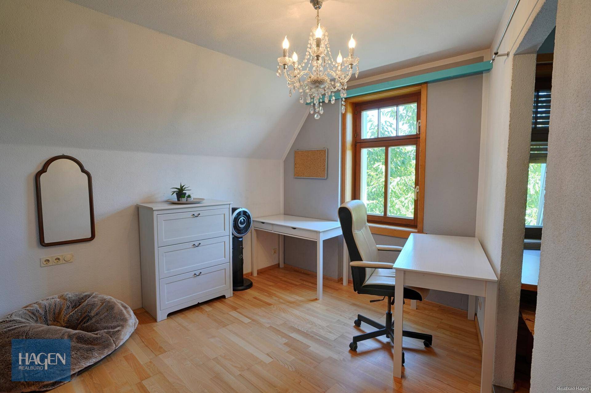 Helles Büro oder Schlafzimmer im Dachgeschoss mit Schreibtischen und Kronleuchter.