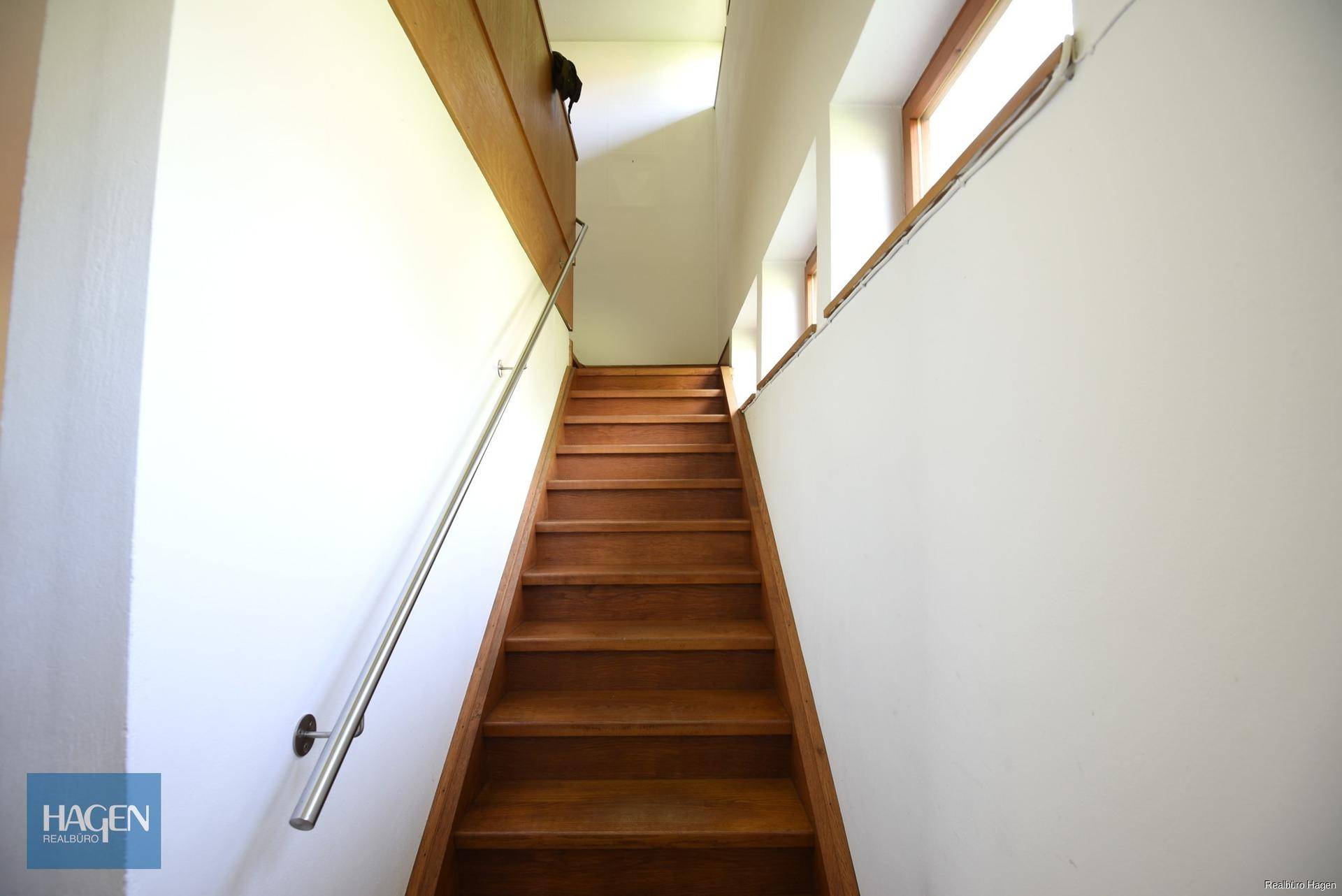 Holztreppe mit modernem Geländer, die die Stockwerke verbindet.