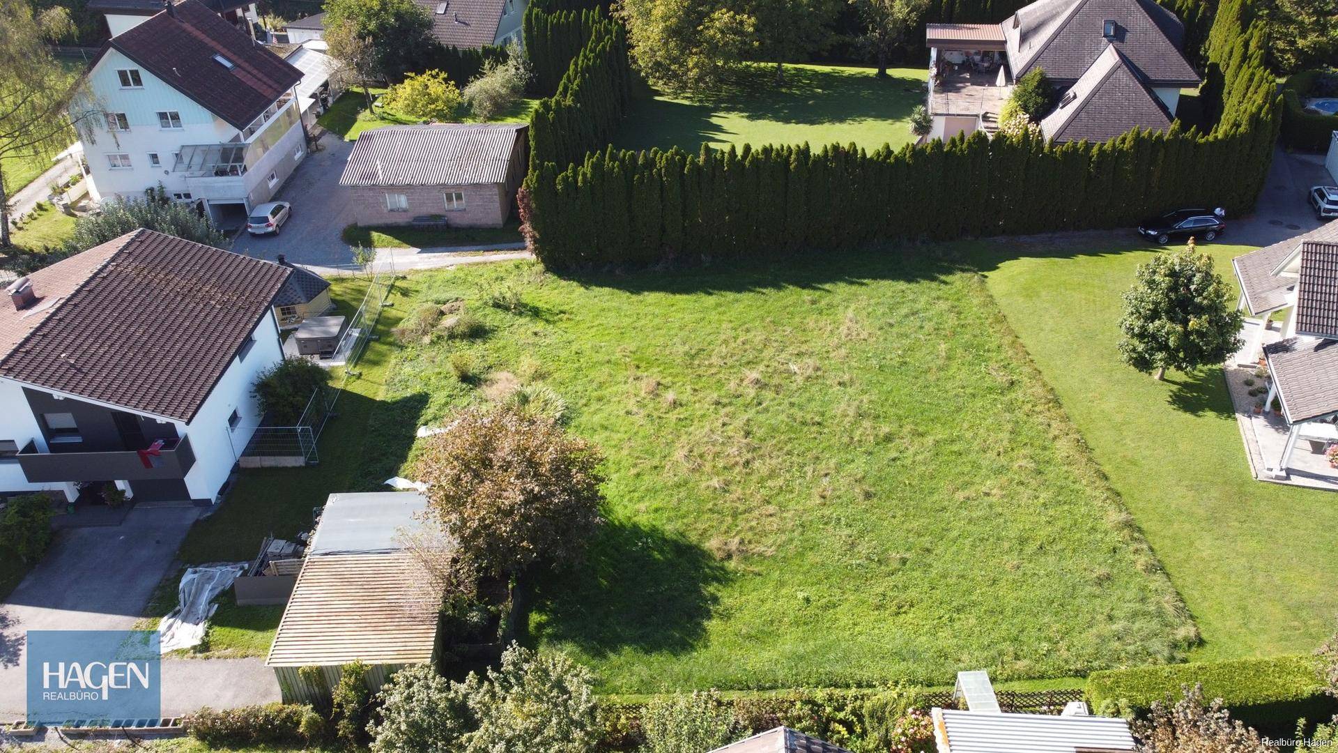 Übersicht aus der Vogelperspektive auf ein großes Wiesengrundstück mit angrenzenden Häusern.