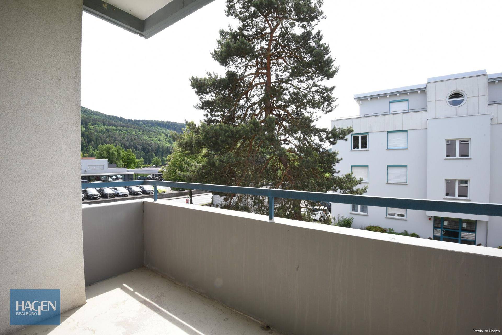 Balkon mit Blick auf die Umgebung und einen großen Baum, ideal zum Entspannen im Freien.