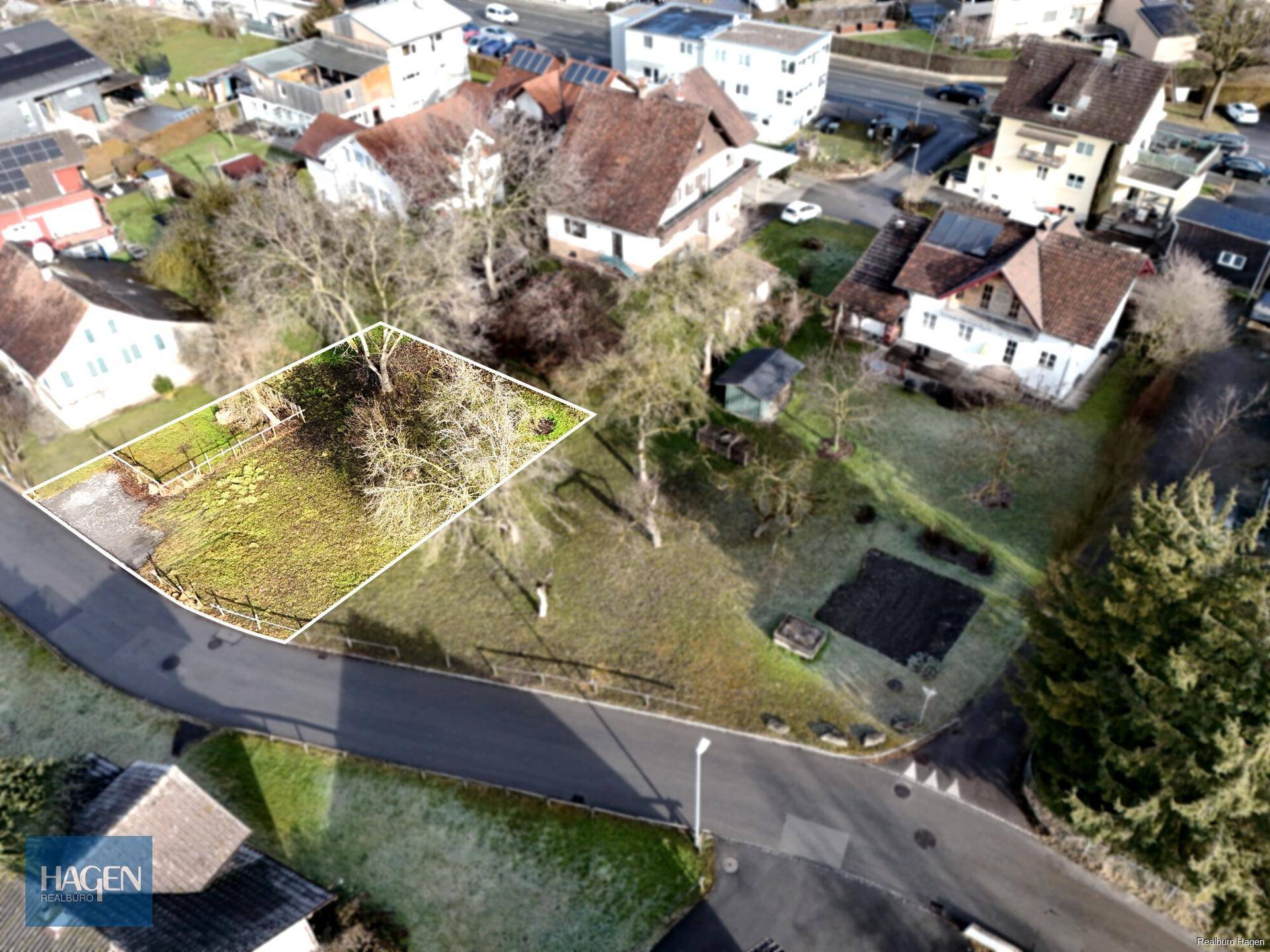 Luftaufnahme eines Grundstücks mit umliegenden Häusern und Straßen in einer Wohngegend.