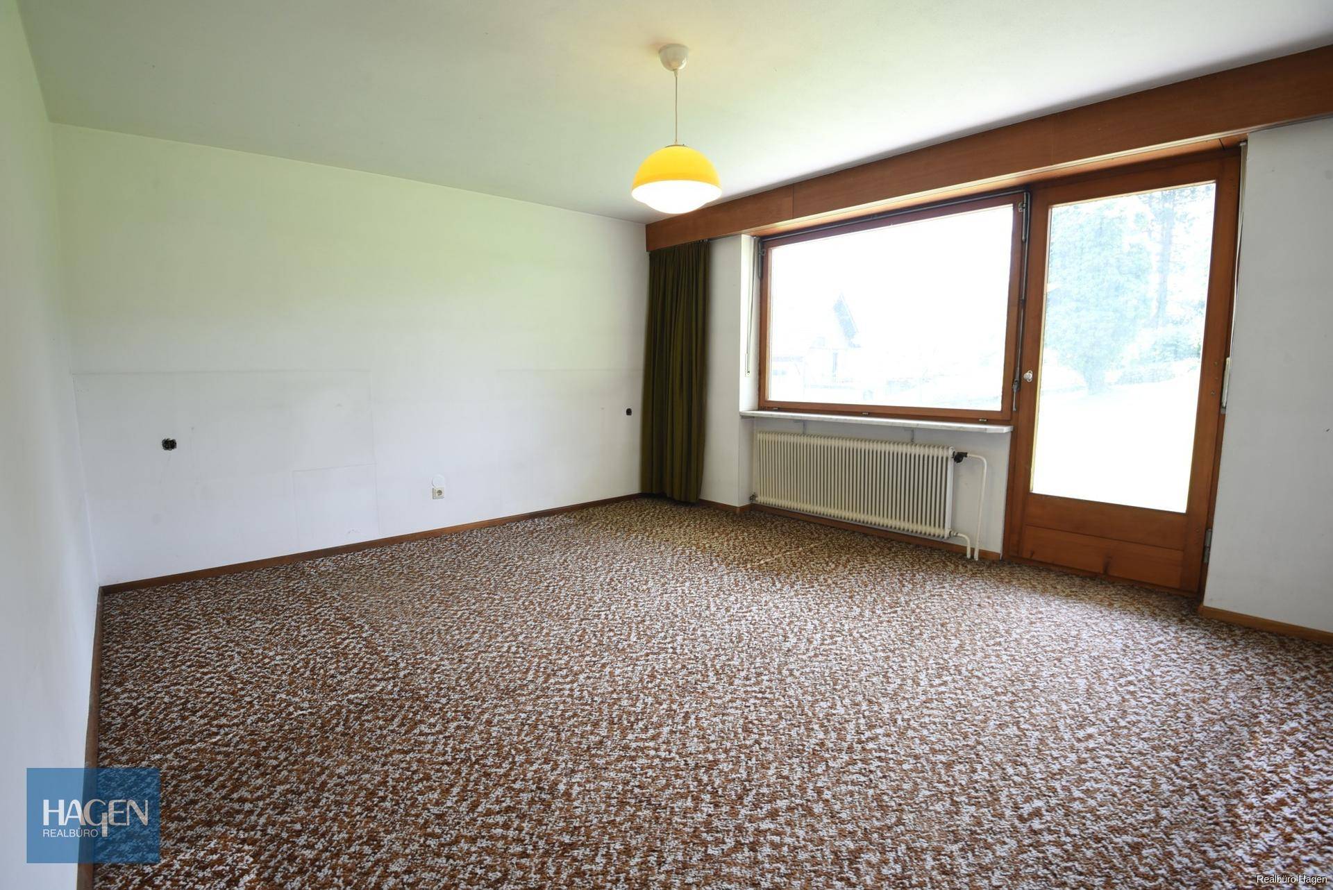 Geräumiges Zimmer mit Teppichboden, großem Fenster und Zugang zum Garten.