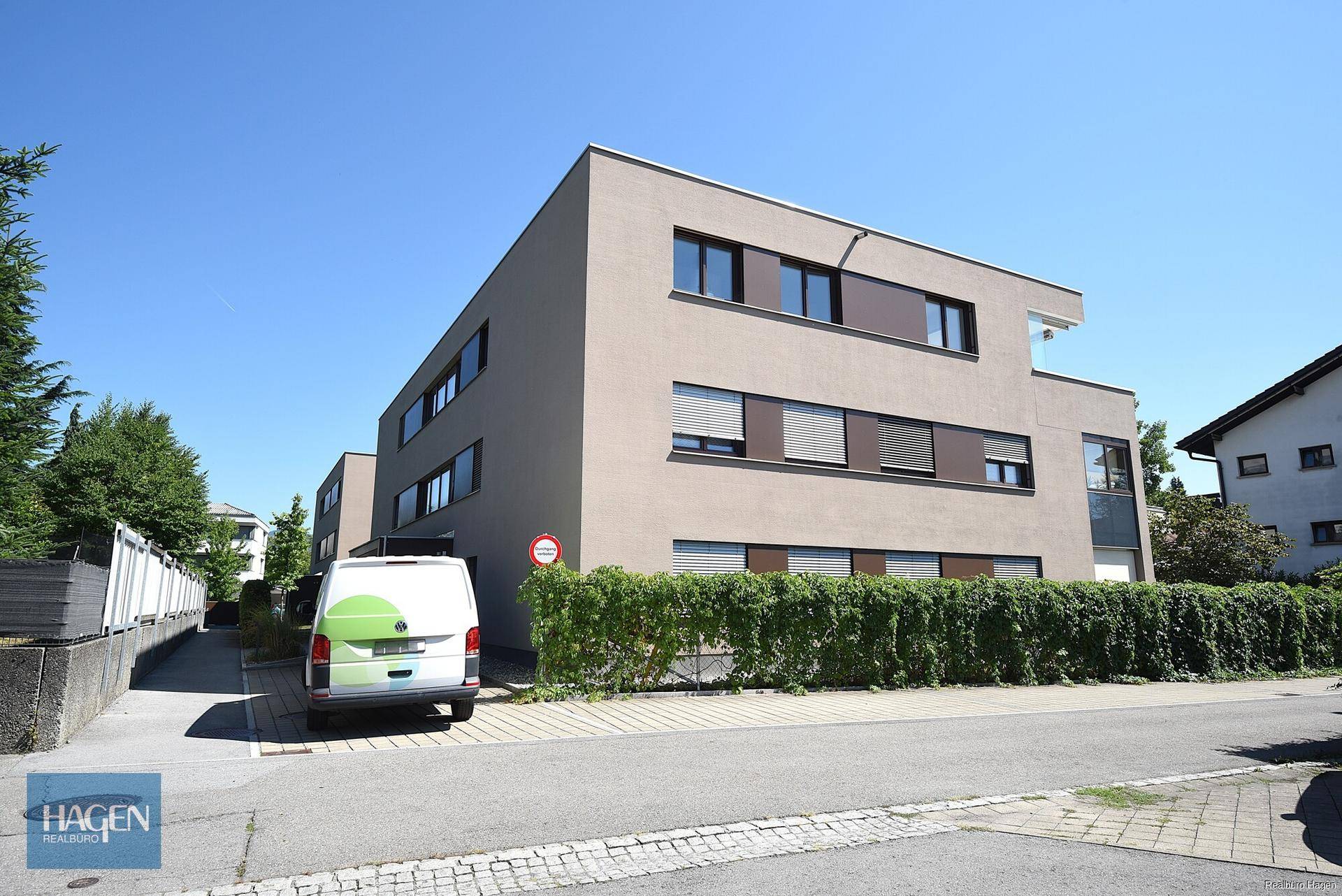 Modernes Mehrfamilienhaus mit klarer Architektur und gepflegter Außenanlage.