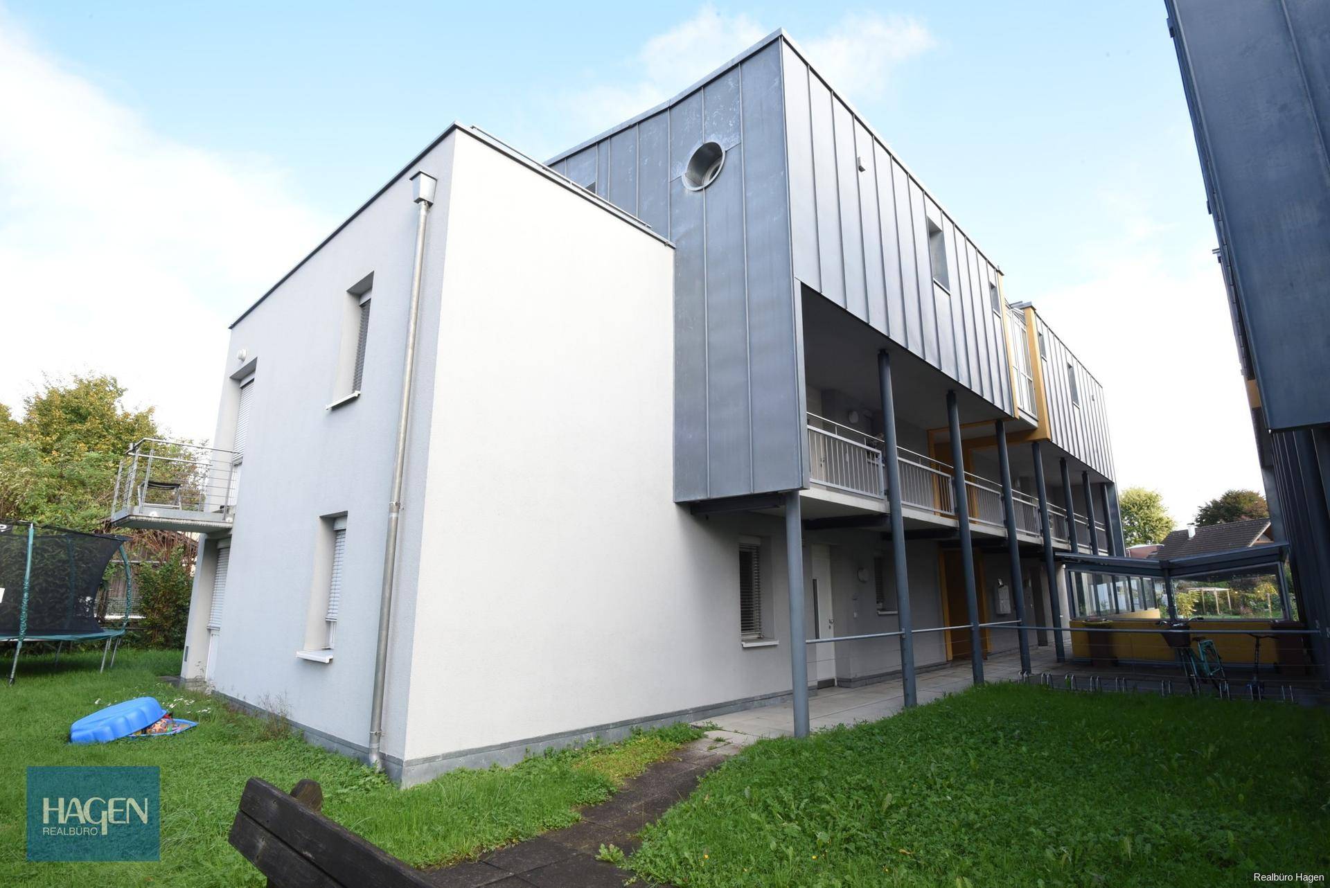 Seitenansicht der modernen Wohnanlage mit langen Balkonen und Metallgeländern.