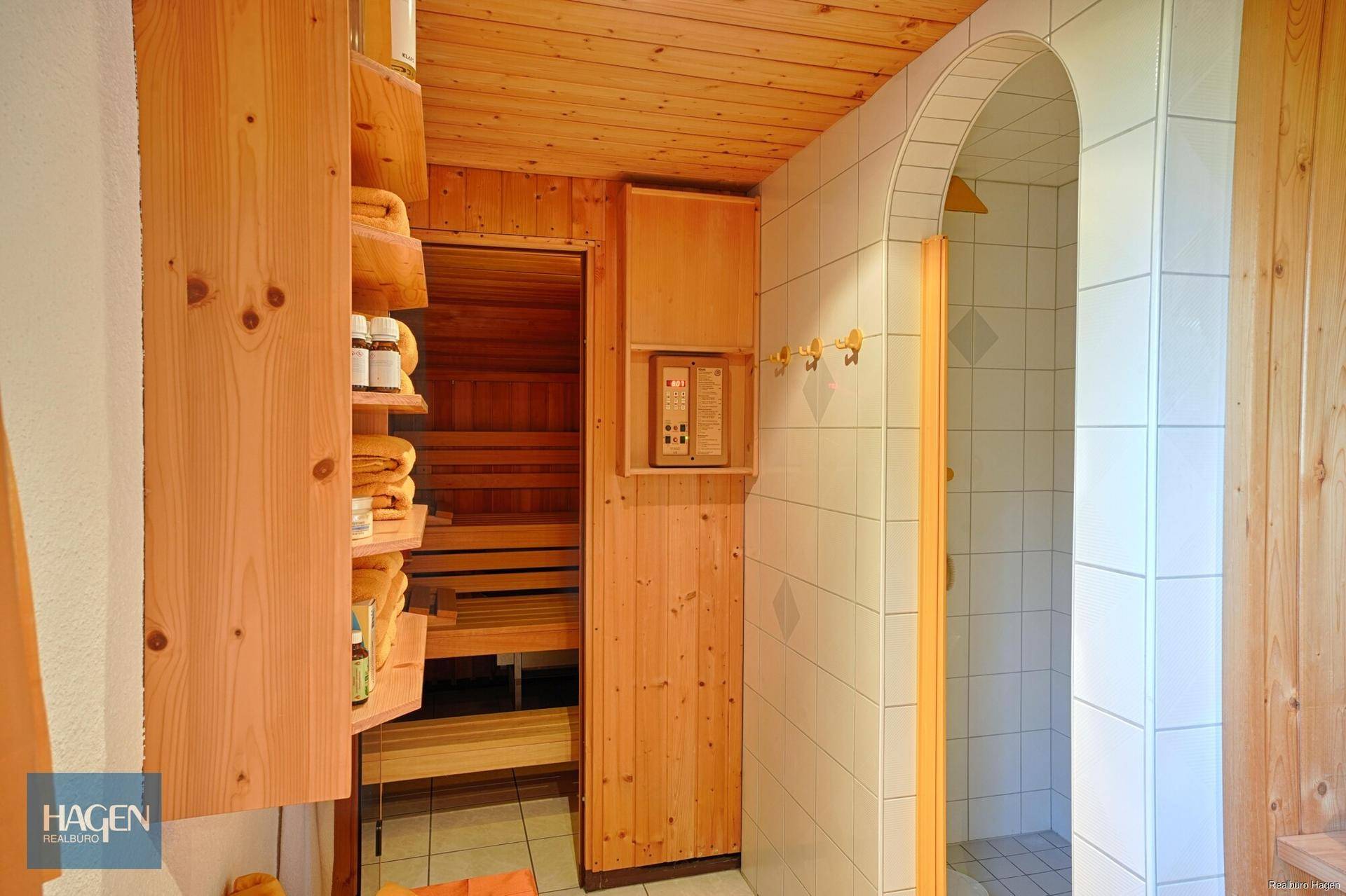 Private Sauna mit angrenzender Dusche und Holzverkleidung für Entspannung.