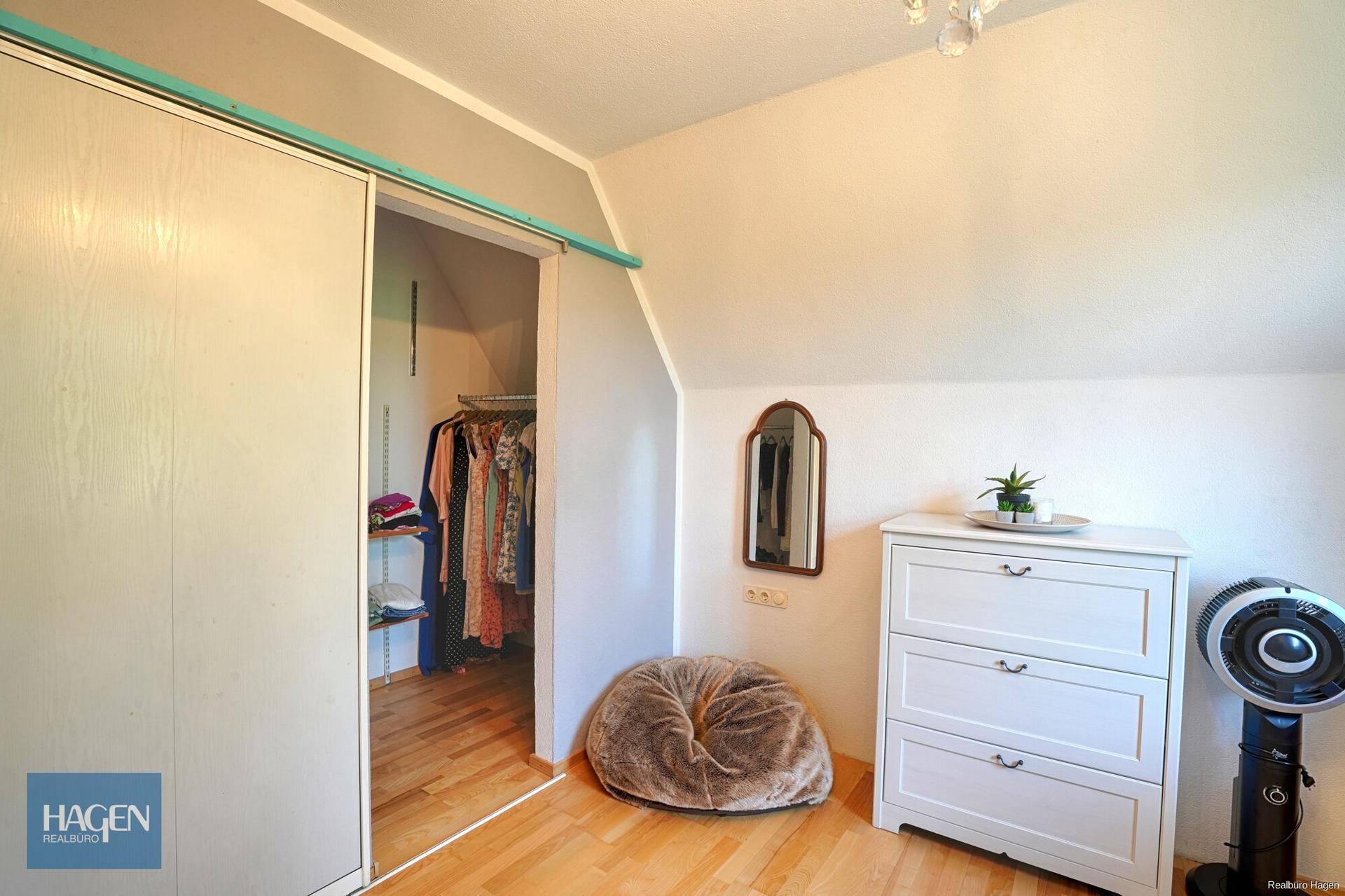 Büro oder Schlafzimmer im Dachgeschoss mit begehbarem Kleiderschrank und Holzboden.