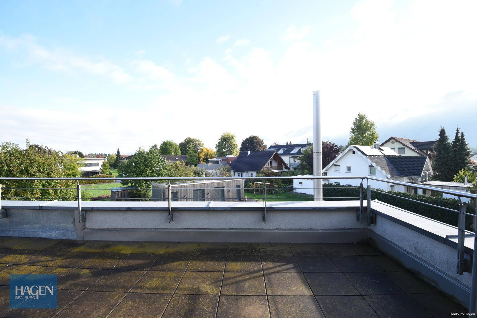 Geräumige Dachterrasse mit Fliesenboden und weitem Blick über die Umgebung.