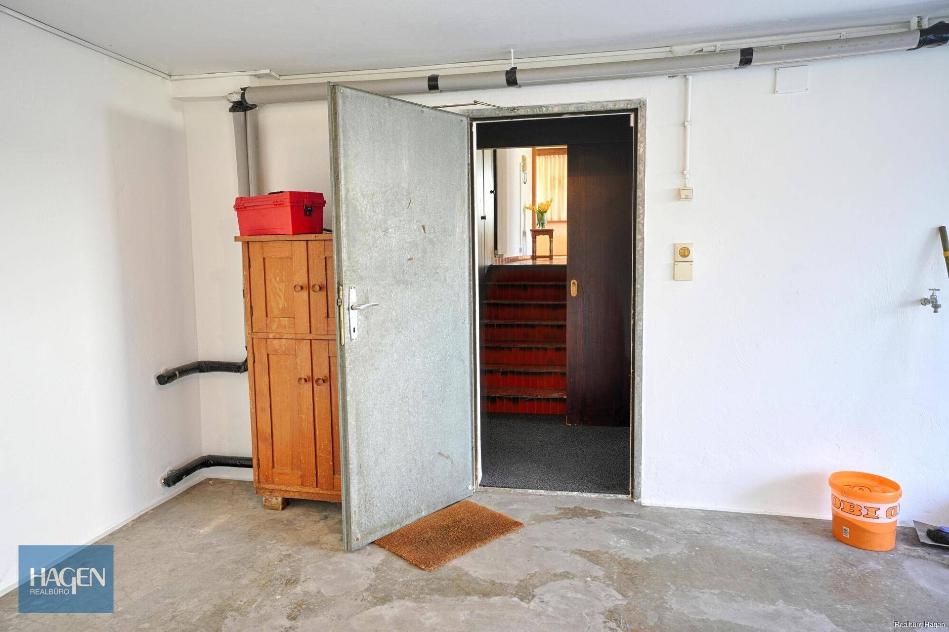 Zugang zur Garage vom Innenbereich des Hauses mit Betongussboden.