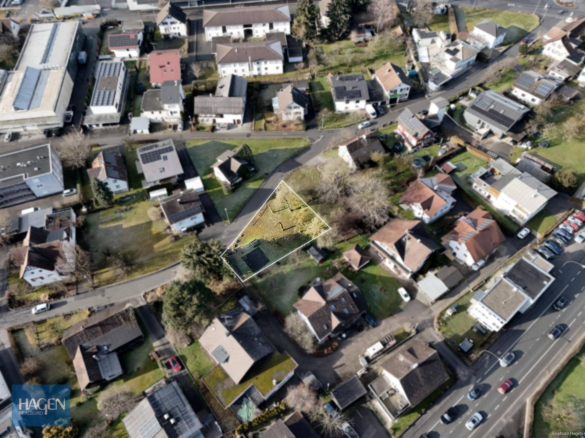 Weitläufige Luftaufnahme eines Grundstücks in einer Wohngegend mit umliegenden Gebäuden und Dächern mit Solaranlagen.