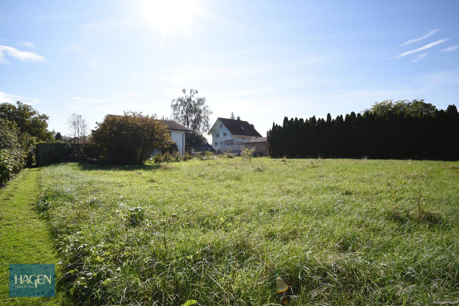 Sonniges Wiesengrundstück mit umliegenden Häusern und viel natürlichem Licht am Tag.