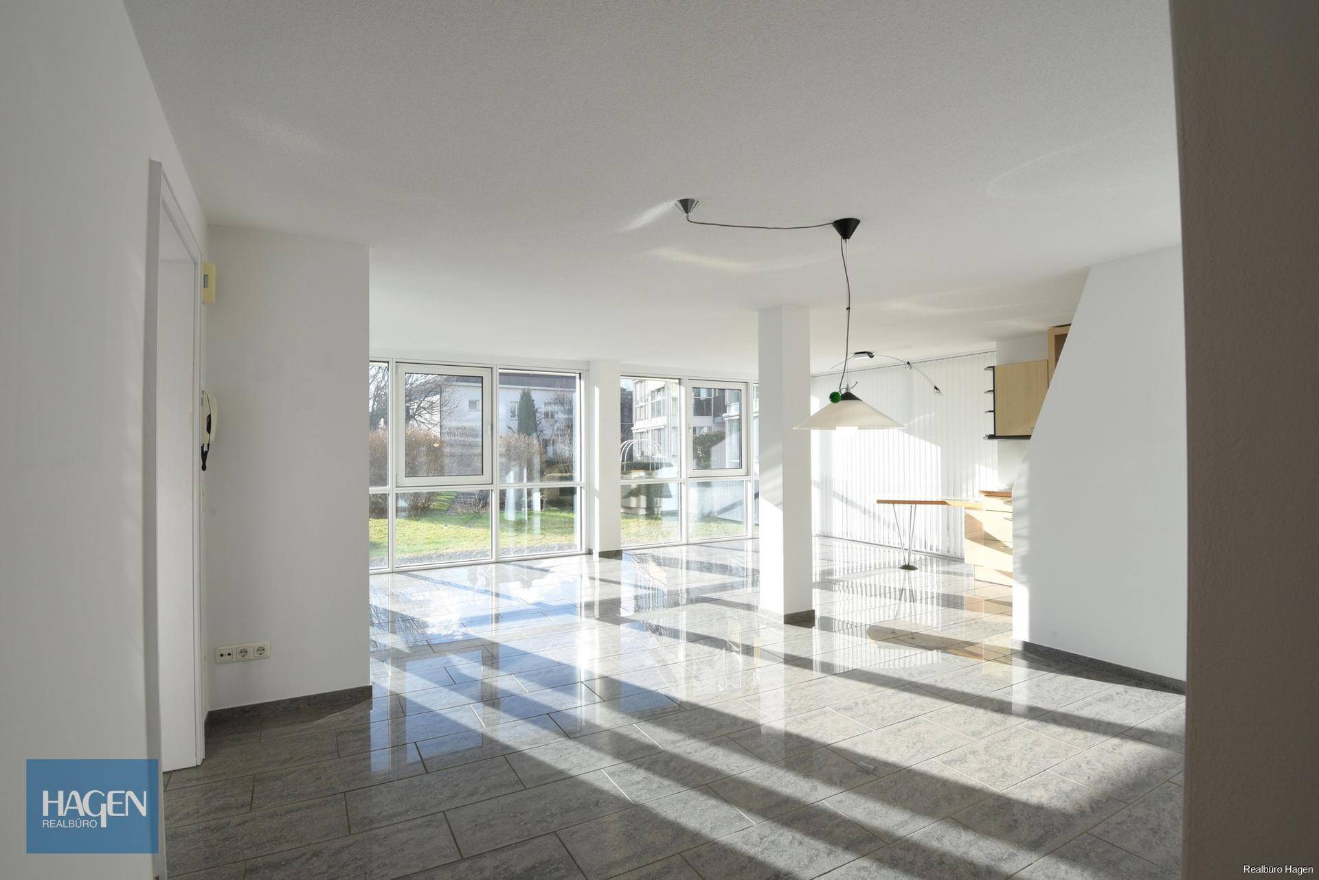 Geräumiger Wohnbereich mit Fliesenboden und viel Sonnenlicht, ideal für individuelle Gestaltung.
