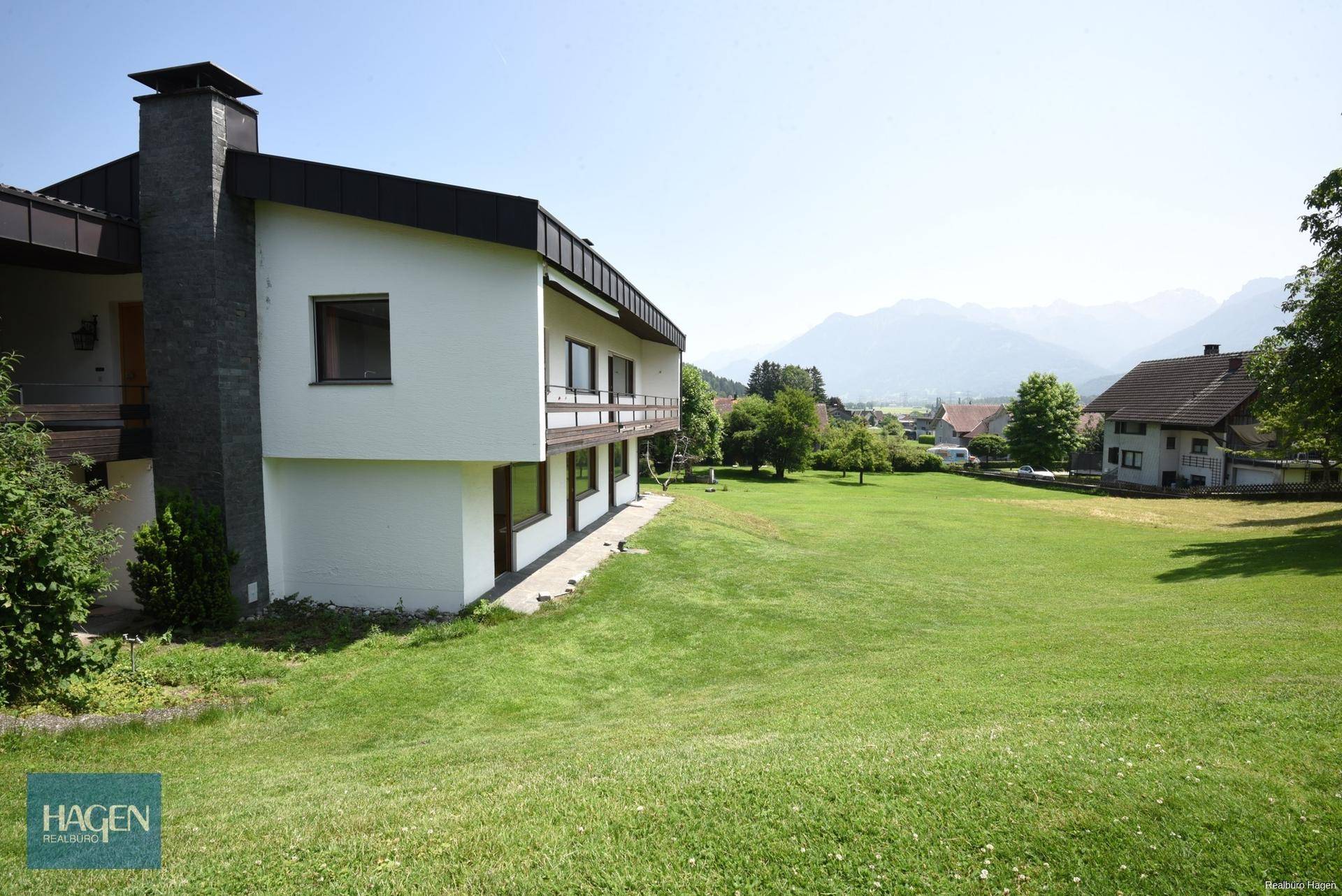 Ansicht des Hauses von der Seite mit großem Garten und Bergblick.