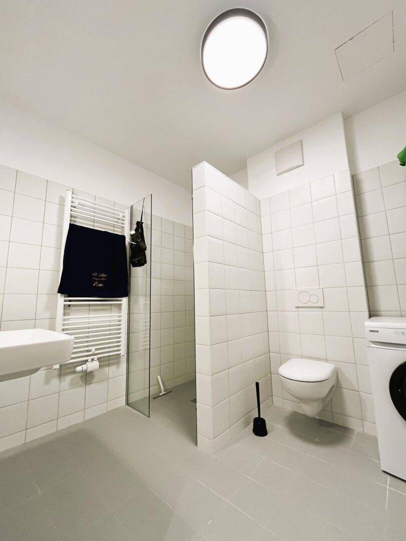 Modernes Badezimmer mit Waschmaschine und zweitem WC