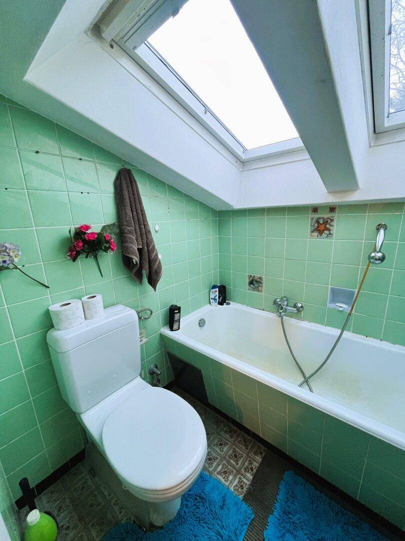 Badezimmer mit Badewanne, Fenster, WC und Waschbecken