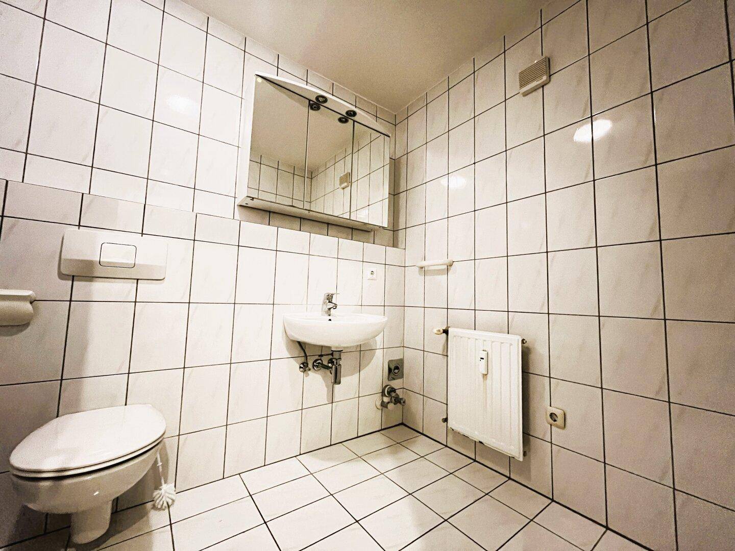 Badezimmer mit Badewanne, WC, Waschbecken und Waschmaschinenanschluss