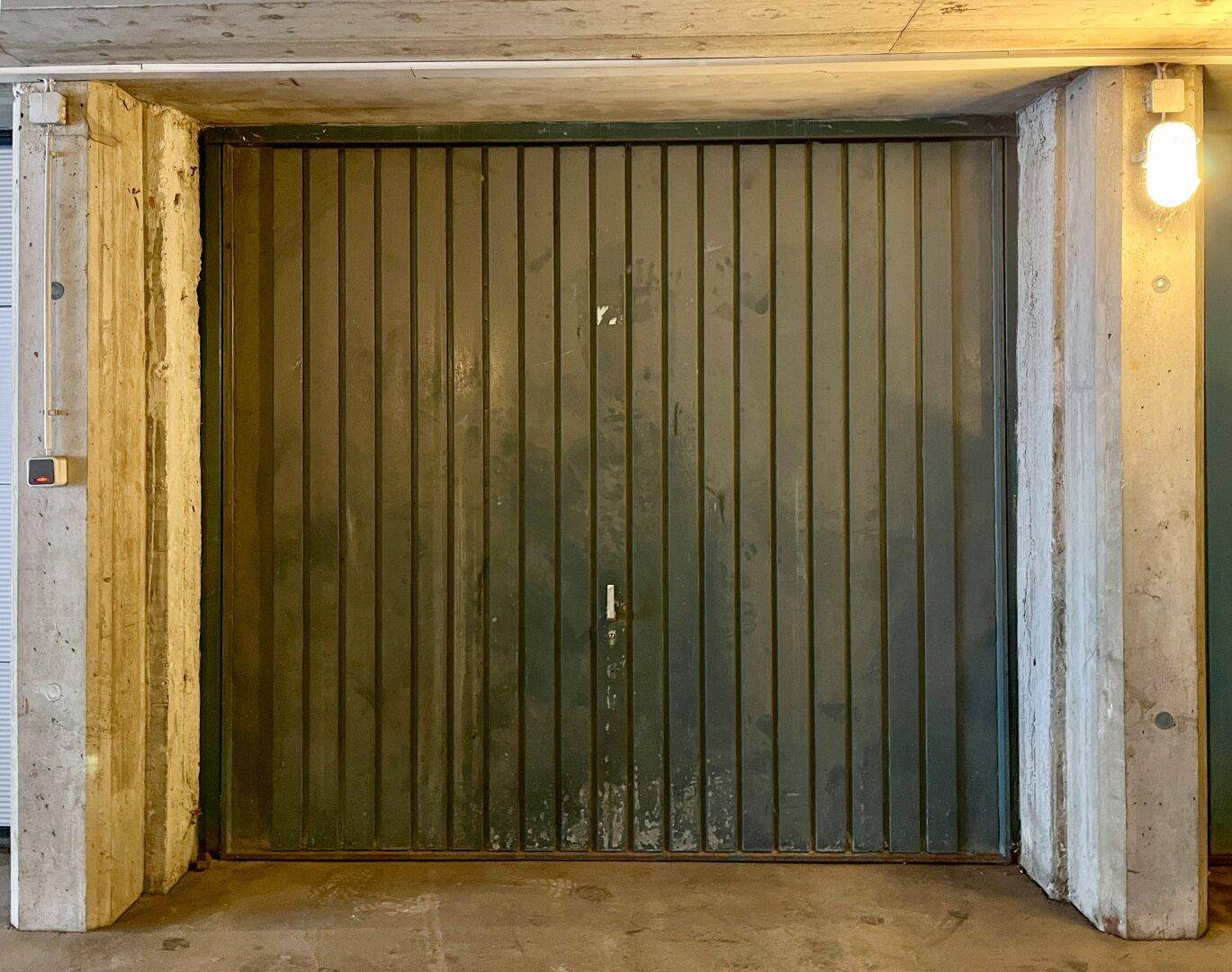 Geschlossenes Garagentor aus Metall, umgeben von robusten Betonpfeilern.