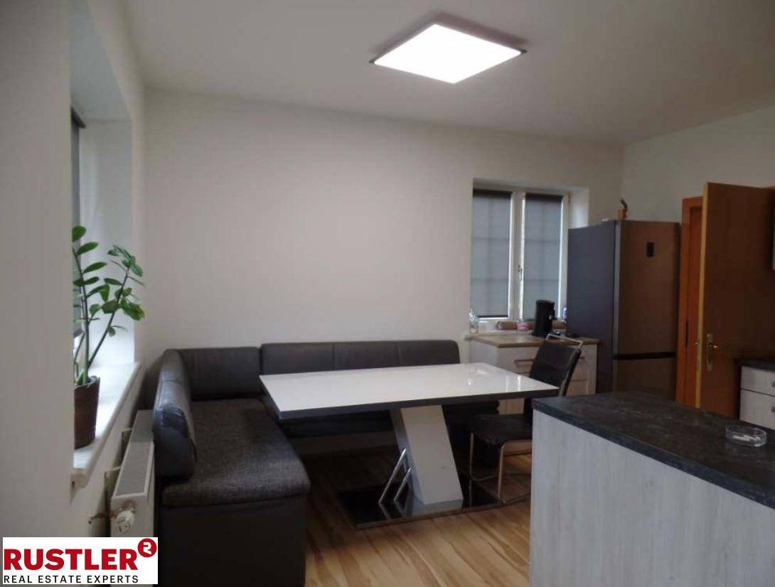 Essbereich mit Eckbank, modernem Tisch und Blick auf den Kühlschrank.