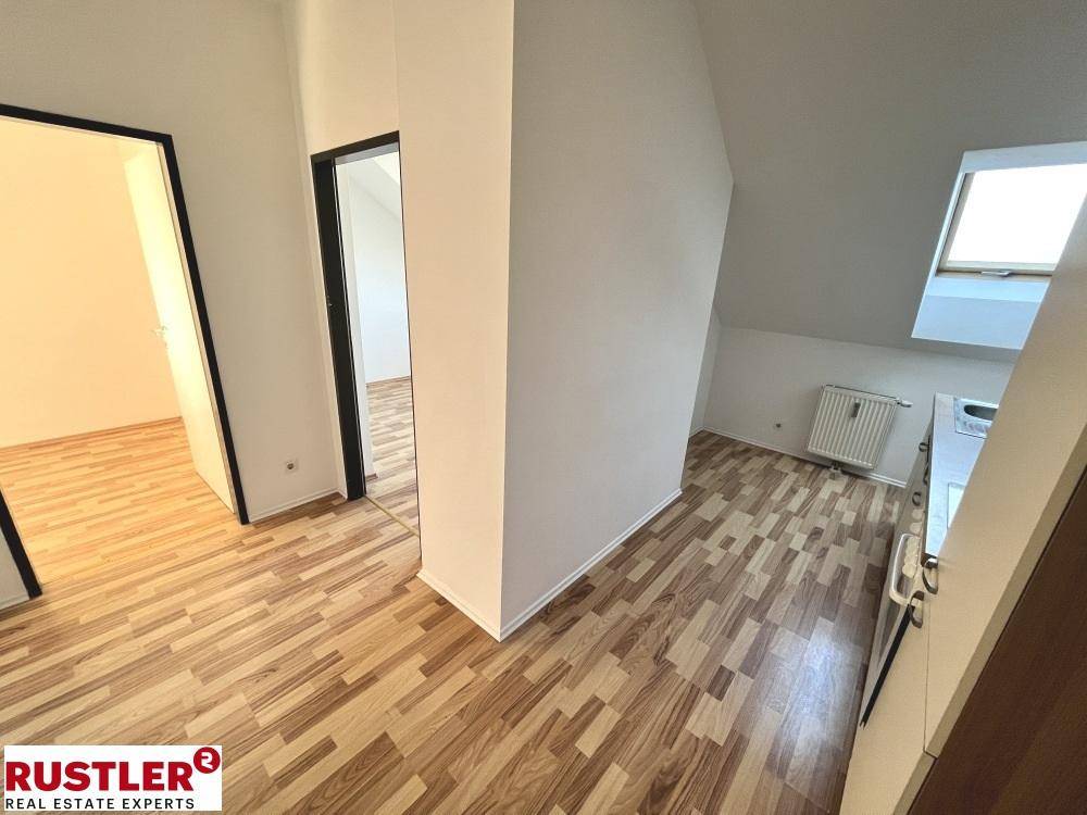 Heller Flur im Dachgeschoss mit Laminatboden und Zugang zu weiteren Zimmern.