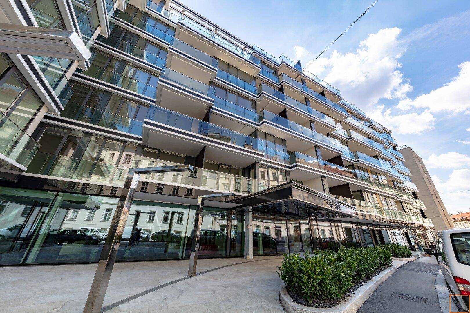 Moderne Wohnanlage mit Glasfassade, zahlreichen Balkonen und zeitgenössischer Architektur.