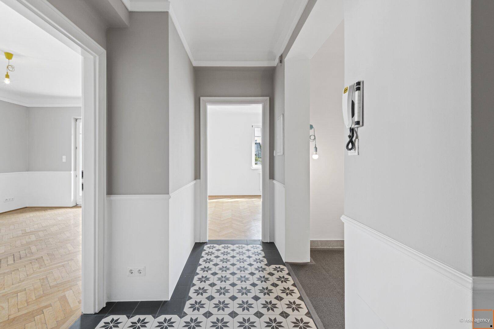 Heller Flur mit gemusterten Bodenfliesen und Zugang zu verschiedenen Räumen der Wohnung.