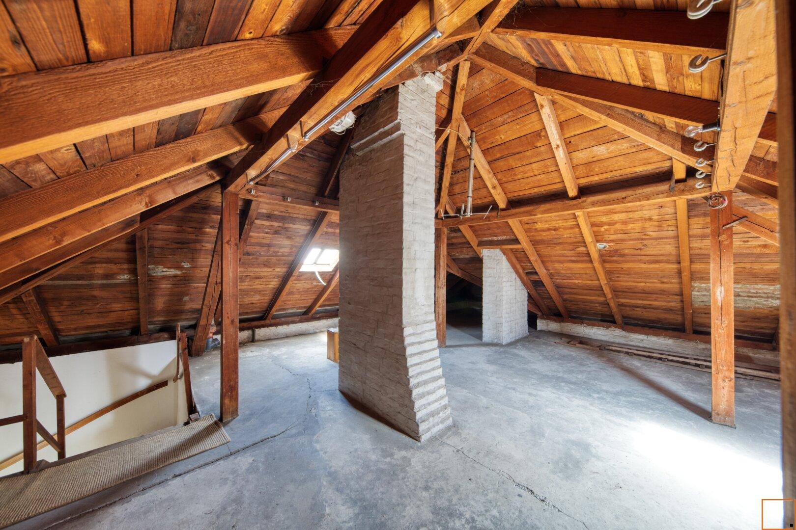 Geräumiger Dachboden mit sichtbaren Holzbalken und viel Potenzial für einen Ausbau.