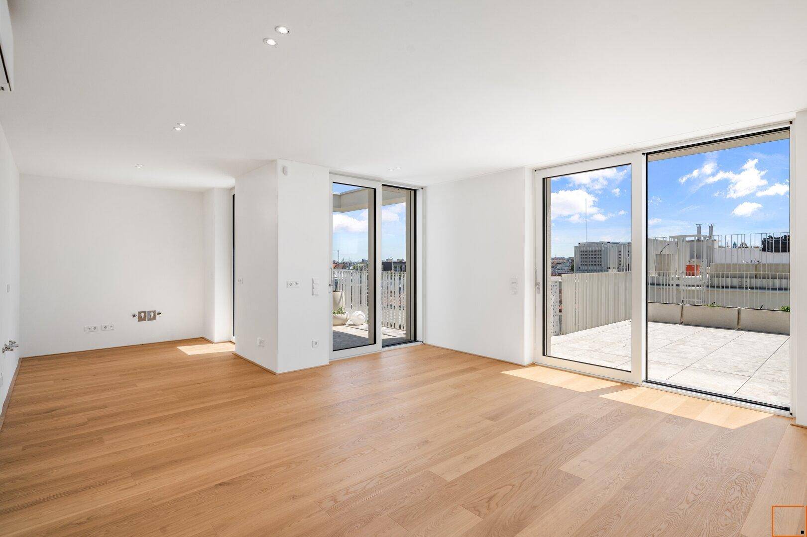 Heller Wohnraum mit Eichenparkett und großen Schiebetüren zur sonnigen Terrasse.