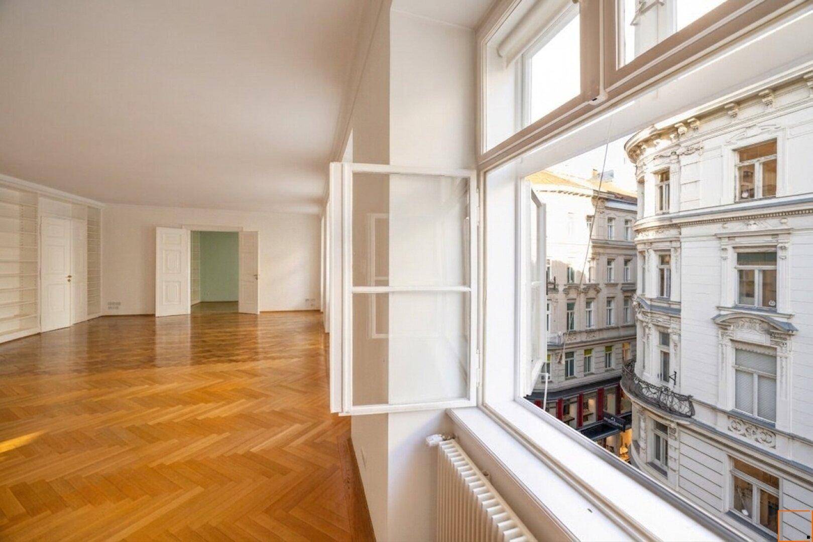 Blick aus dem Fenster auf die historische Straßenansicht und die Fassade eines gegenüberliegenden Altbaus.