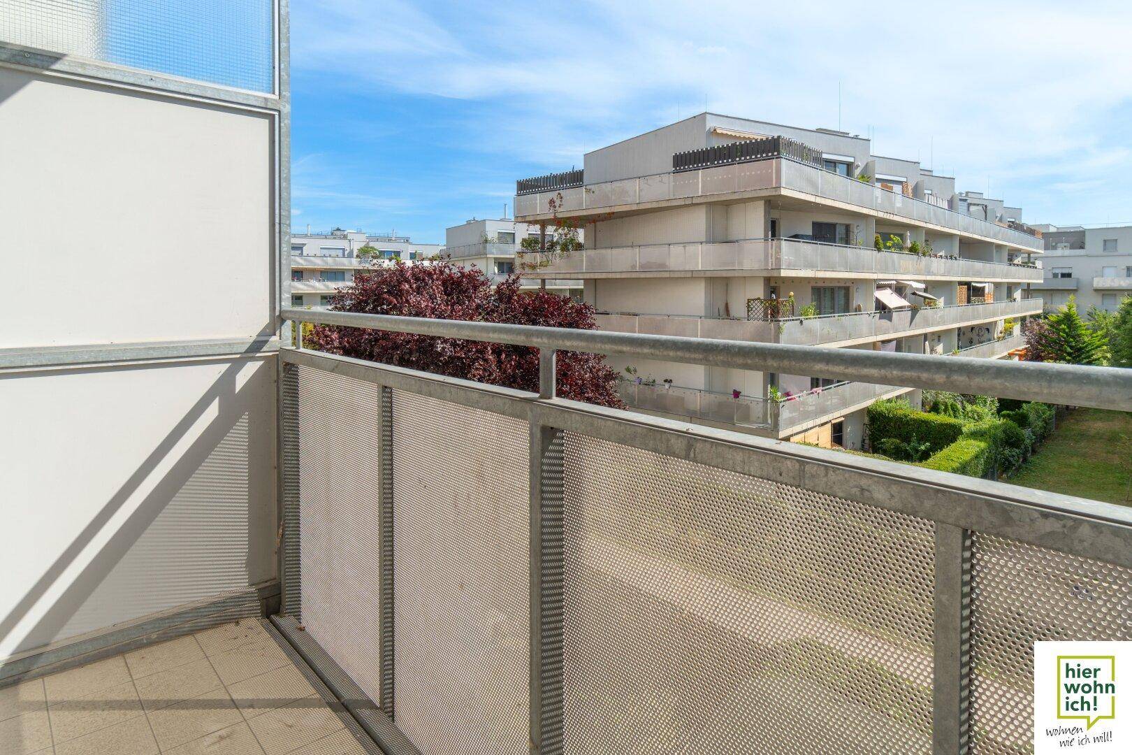 Geräumiger Balkon mit Metallgeländer bietet eine angenehme Aussicht auf die grüne Umgebung.