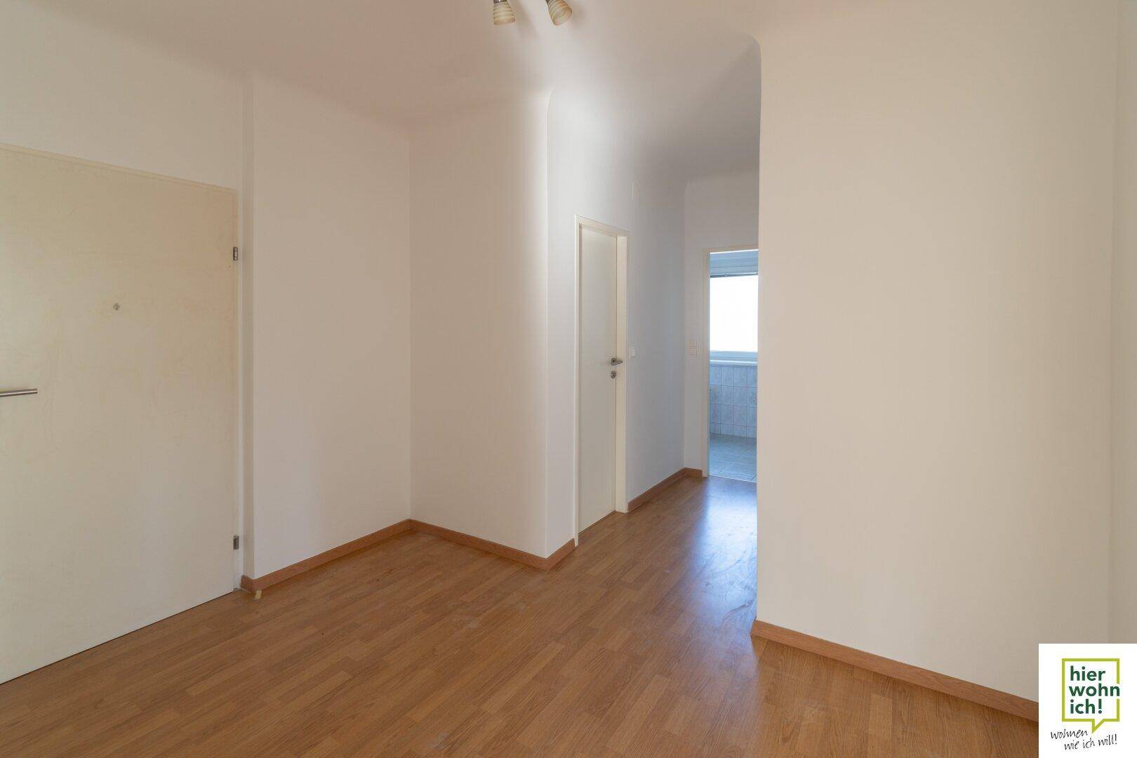 Heller Übergangsbereich mit Parkettboden, der verschiedene Zimmer miteinander verbindet.