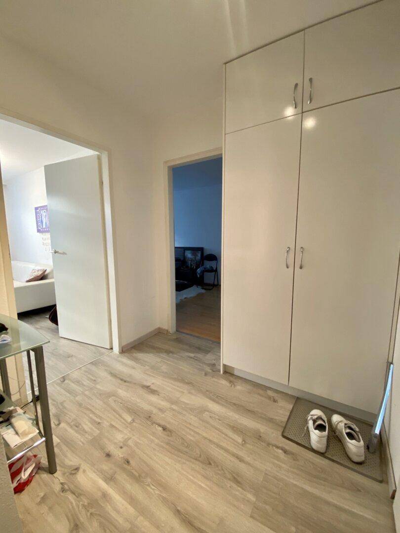 Heller Flur mit Laminatboden und praktischen Einbauschränken.