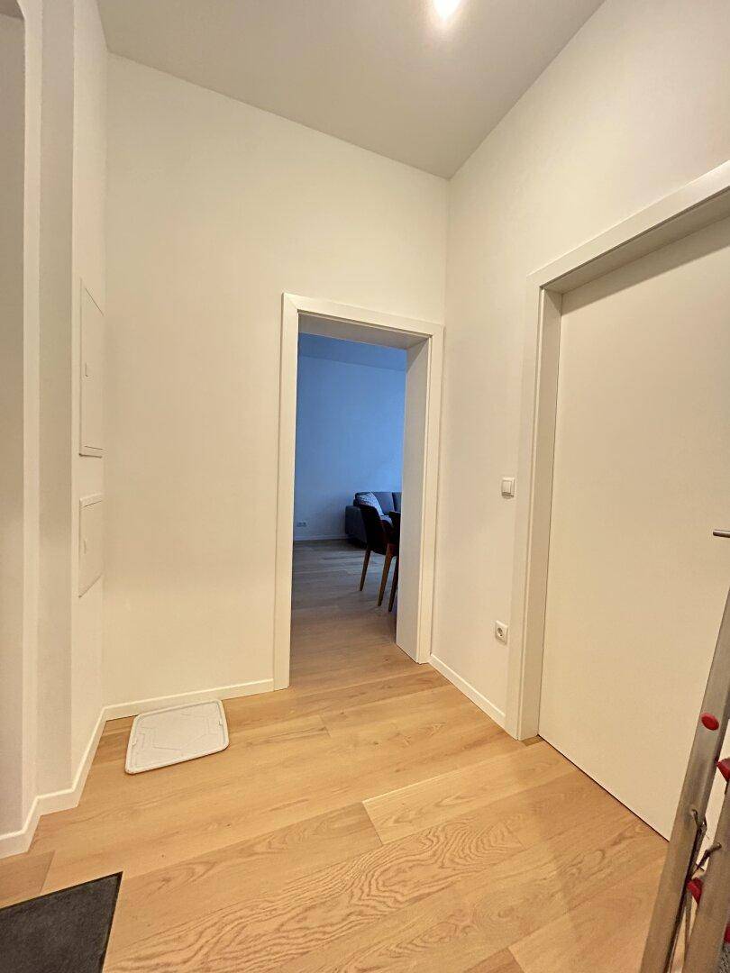 Heller Flur mit Holzboden, der zu den anderen Räumen der Wohnung führt.